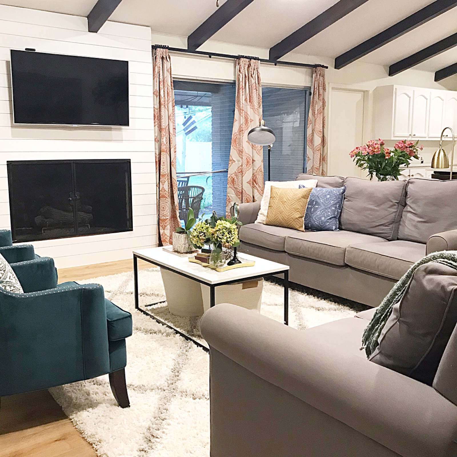 Living room with beamed ceiling and teal accent chair