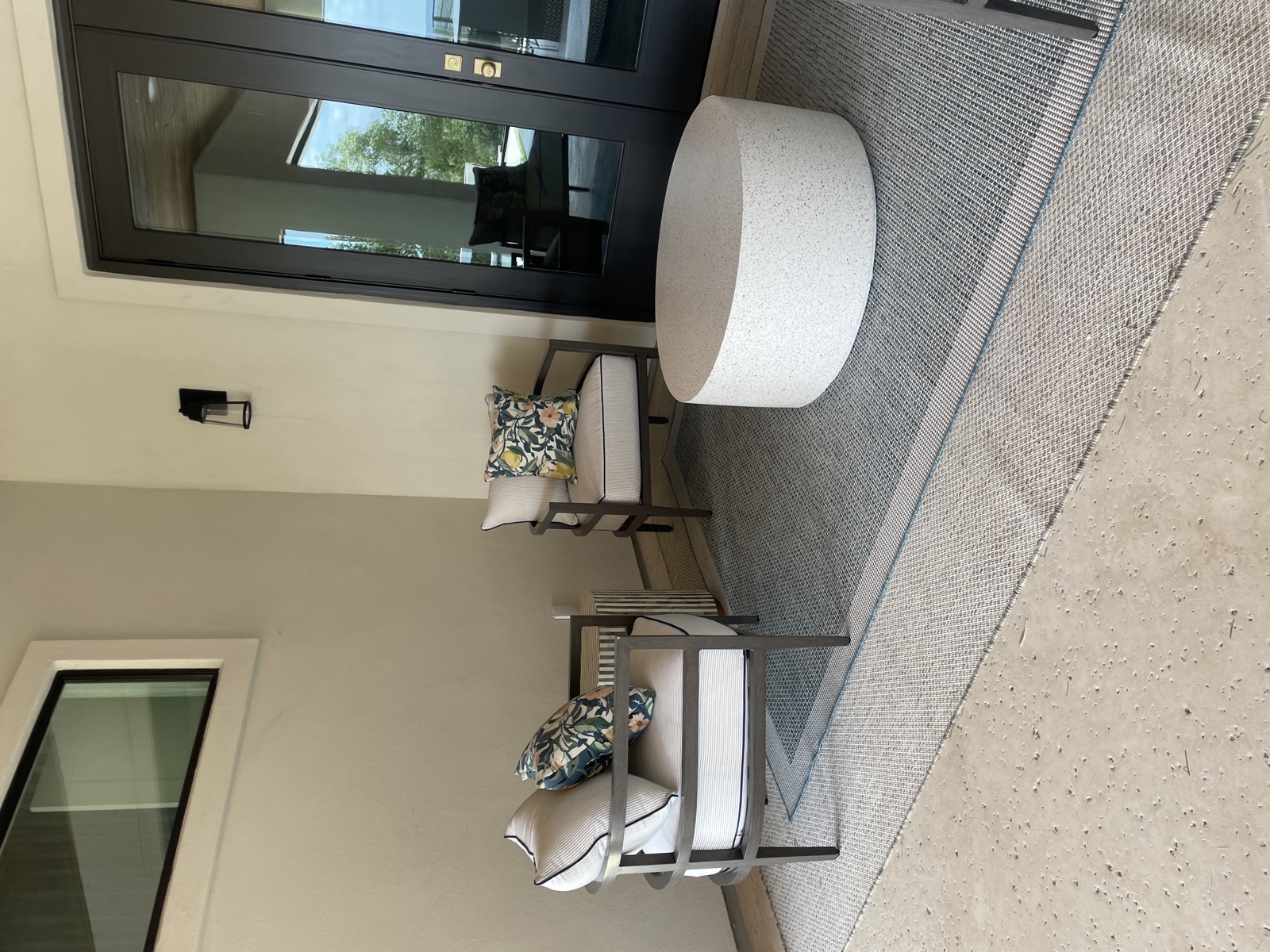 Sitting area with round ottoman and grey area rug