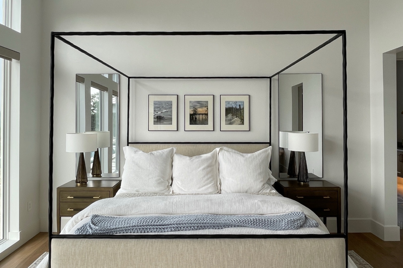 Primary canopy bed with triptych art above the headboard
