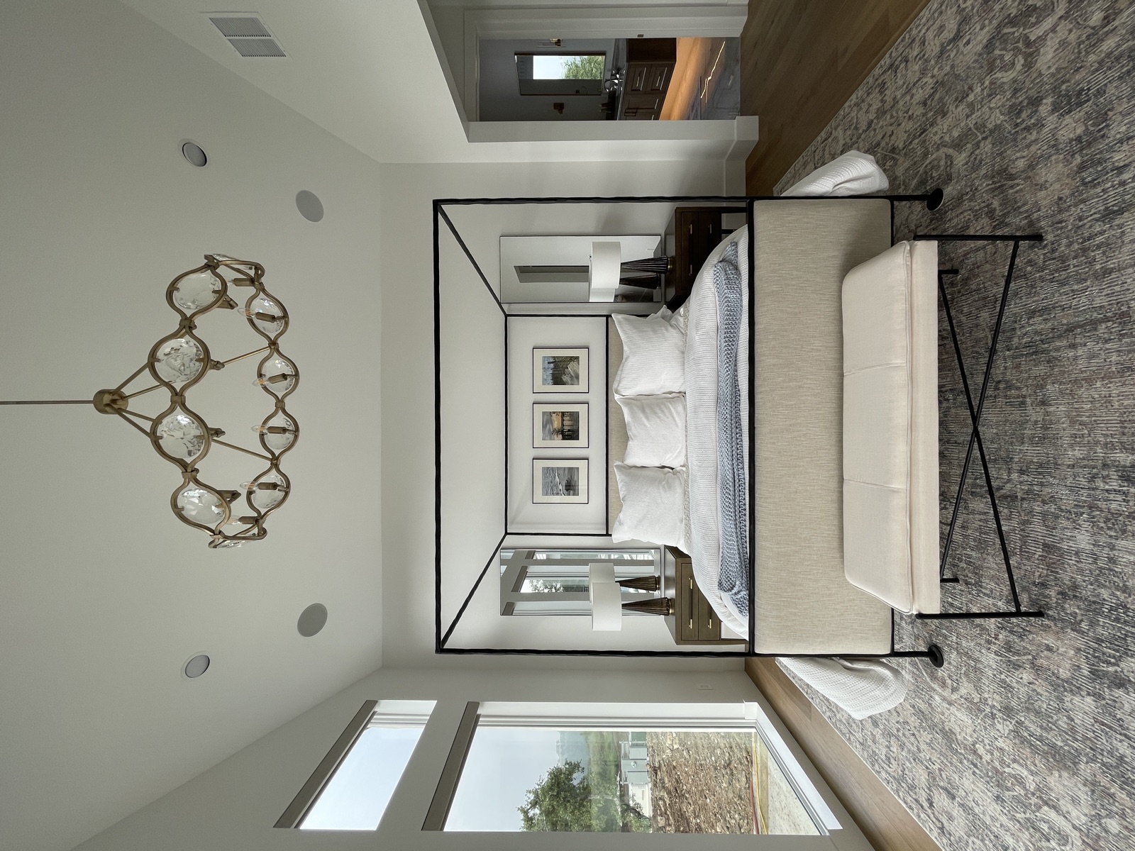 Bedroom with chandelier and upholstered end-of-bed bench