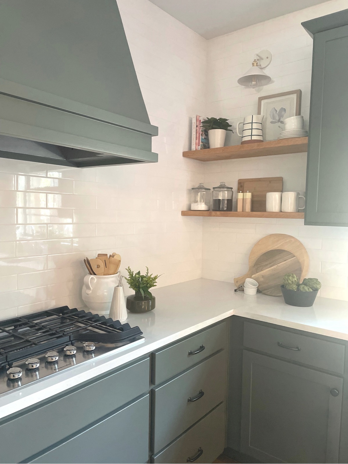 Range wall with floating oak shelves and white backsplash