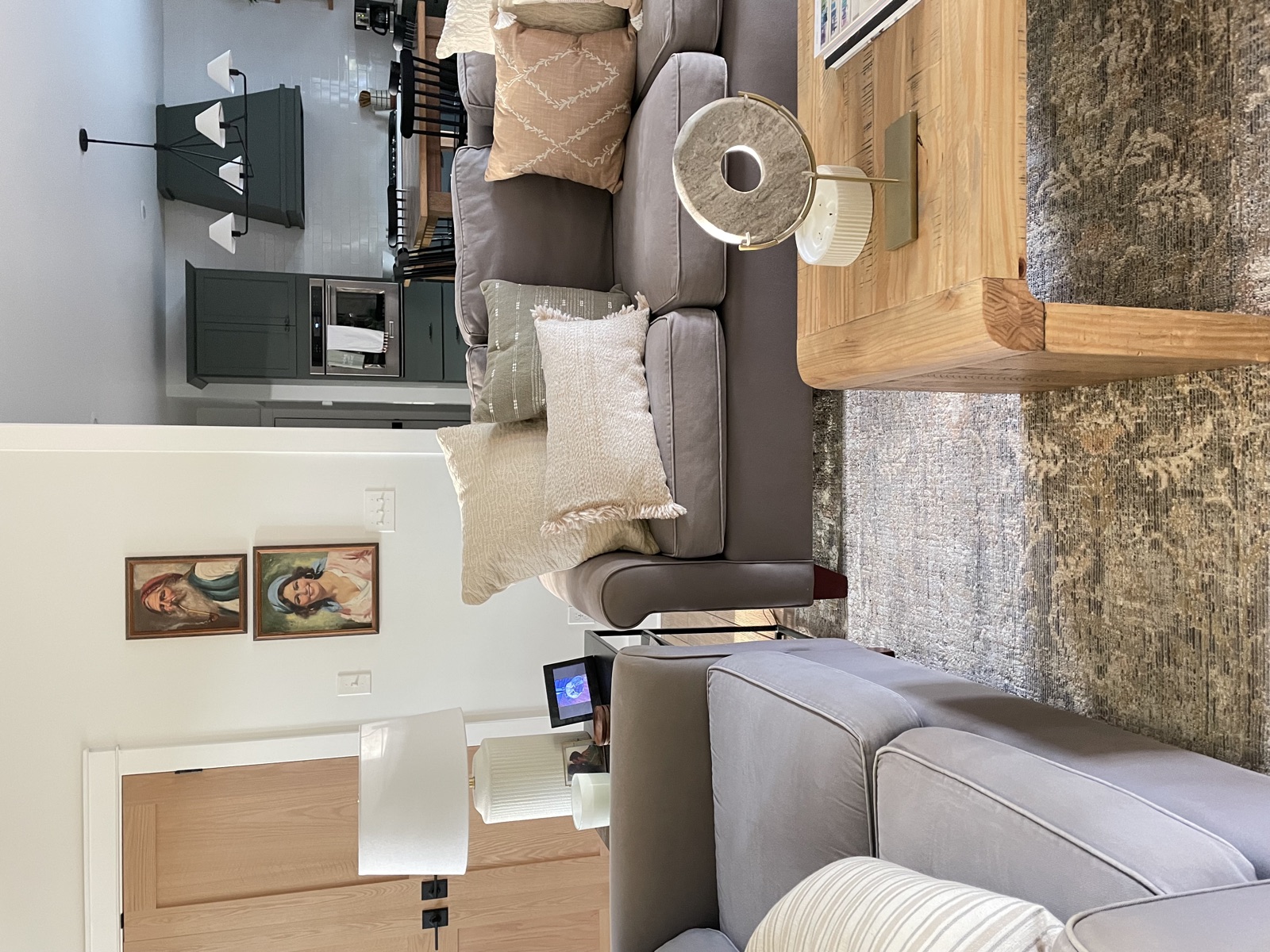 Family room with grey sectional and warm oak tables