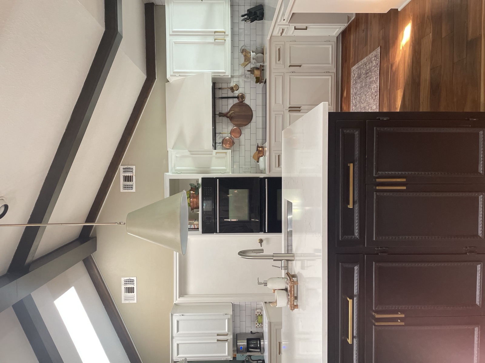 White kitchen with dark island and brass hardware